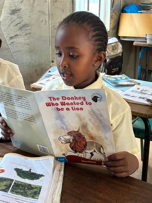 A student absorbed in reading a storybook in class