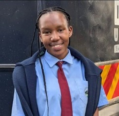 Sandrine, a student at Three Rivers Academy, smiling in her school uniform
