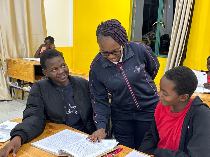 A teacher working closely with two students